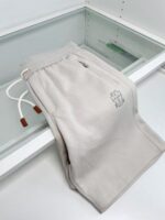 Pantaloni casual beige con elastico, coulisse con gocce in legno e logo ricamato semplice.