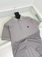 Maglietta polo grigia slim fit con logo elegante, tessuto traspirante e stile minimalista.