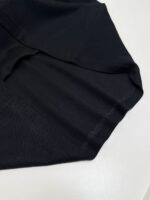 Vestito nero in tessuto elasticizzato con finitura satinata, design minimalista e elegante.