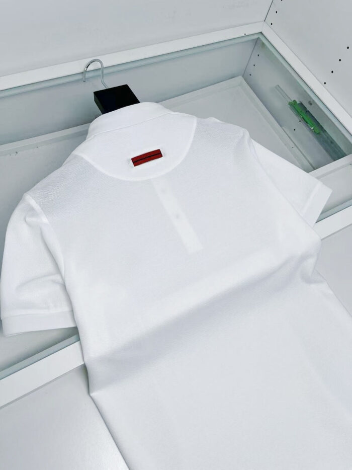 Camicia polo bianca di alta qualità in esposizione elegante, dettagli raffinati e logo discreto.