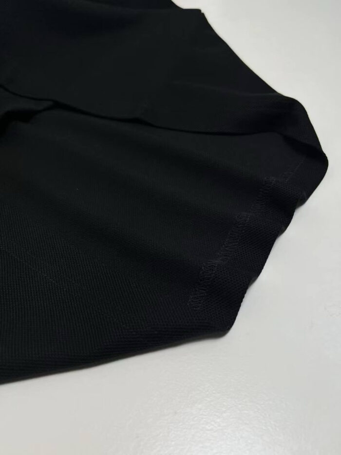 Tessuto nero elegante, morbido e lucido, ideale per abiti femminili raffinati e di stile.