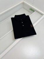 Maglia polo nera elegante su vetrina moderna in stile minimalista, perfetta per look sofisticati.