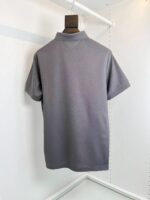 Maglietta polo grigia casual elegante su scaffale, tessuto leggero e stile classico e versatile.