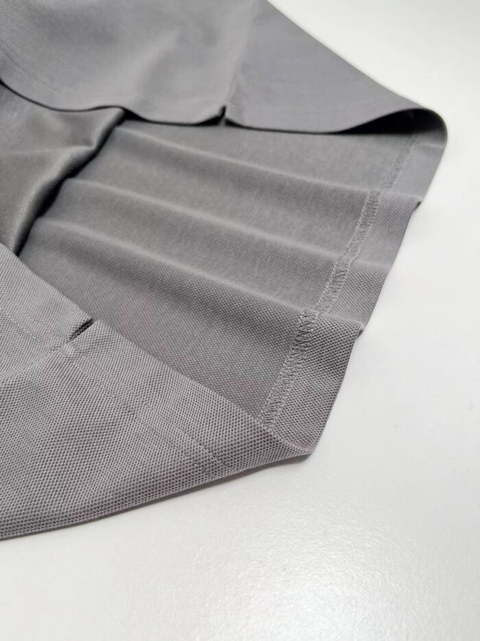 Tessuto grigio elegante con plissettature e dettagli raffinati, ideale per arredamento e moda.