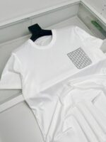 Maglietta bianca con tasca geometrica elegante, casual e versatile, perfetta per ogni occasione.