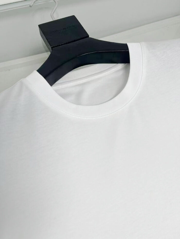 Maglietta bianca classica su appendiabiti nero, versatile e elegante, perfetta per ogni stile casual.