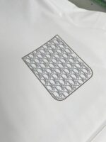 Camicia bianca elegante con tasca logo grigia moderna, stile versatile e raffinato.