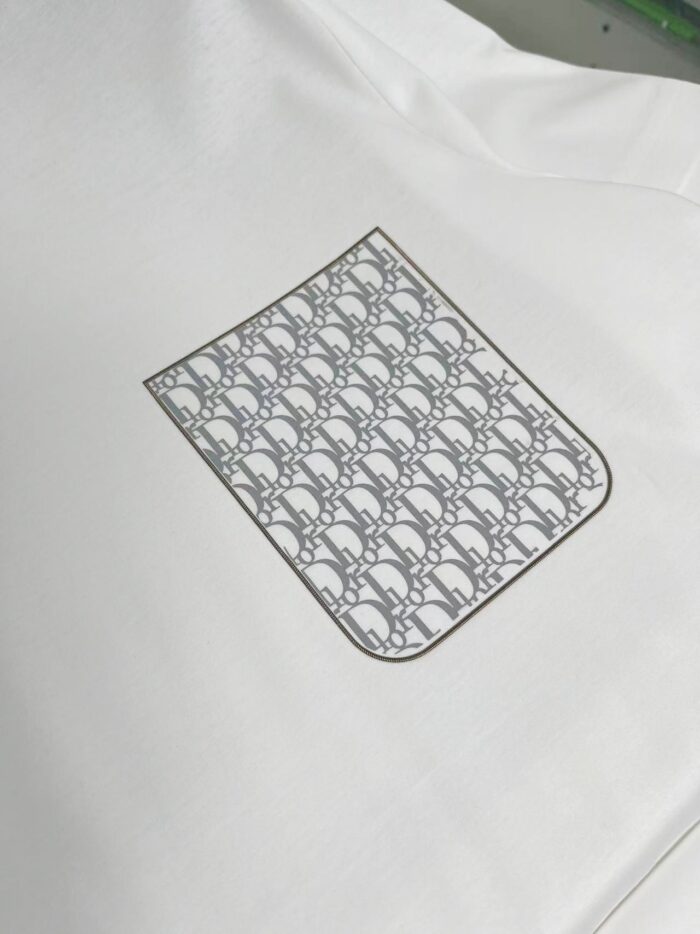 Camicia bianca elegante con tasca logo grigia moderna, stile versatile e raffinato.