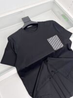 Maglietta nera con tasca geometrica moderna, stile casual ed elegante, perfetta per ogni occasione.