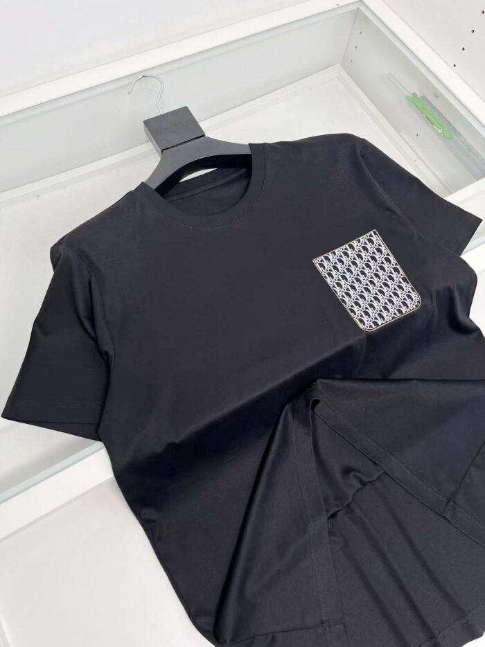 Maglietta nera con tasca geometrica moderna, stile casual ed elegante, perfetta per ogni occasione.