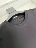 Maglietta nera casual a manica corta su hanger minimalista, stile semplice ed elegante.