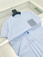 T-shirt azzurro chiaro con tasca a motivi moderni, stile casual e design minimalista.