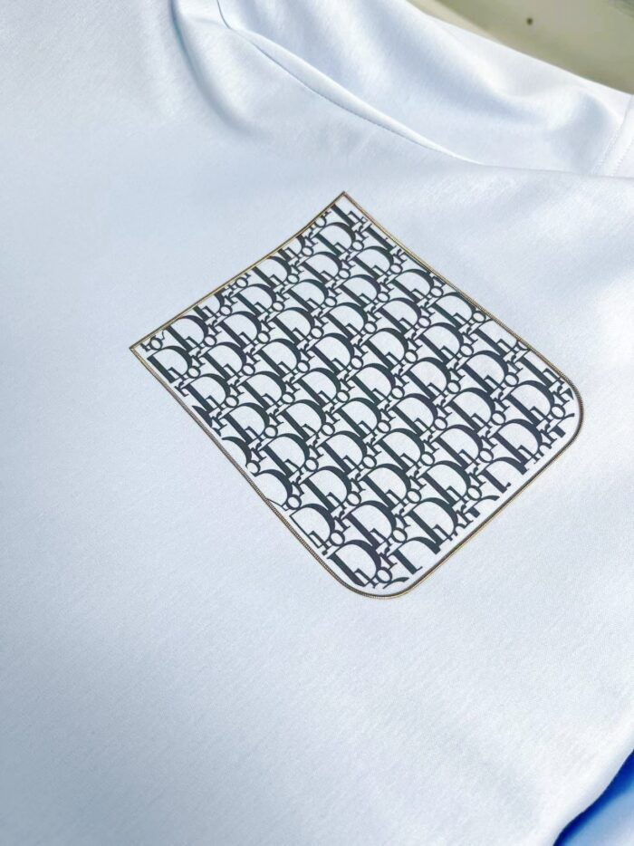 T-shirt bianco con taschino artistico monocromatico, dettaglio elegante e moderno per look casual.