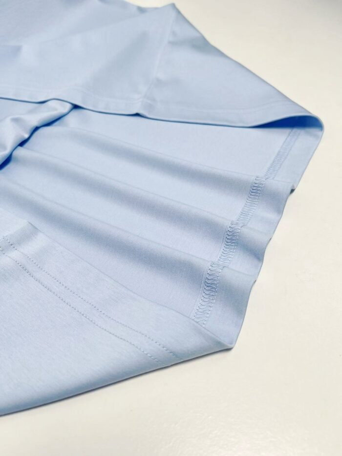 Camicia azzurra in cotone leggero, elegante e ben stirata, ideale per occasioni formali e casuali.