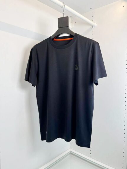 T-shirt nera basic con logo sottile, stile casual e versatile, su appendiabiti in ambiente luminoso