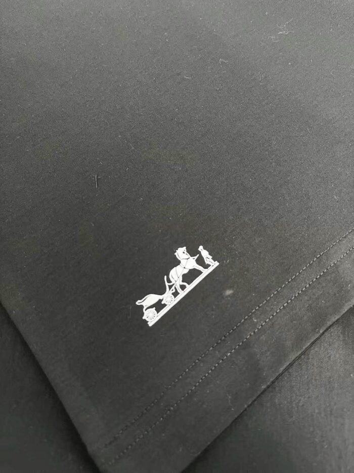 Logo equestre minimalista su tessuto nero raffinato, simbolo di eleganza e qualità.