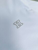 Maglietta bianca con logo grigio minimalista, tessuto elegante e stile raffinato.