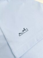 Maglietta azzurra con dettaglio artistico e disegno giocoso sul fondo.