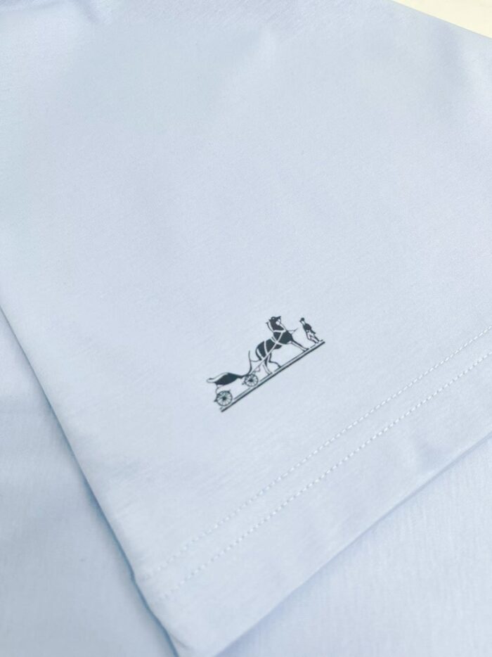 Maglietta azzurra con dettaglio artistico e disegno giocoso sul fondo.