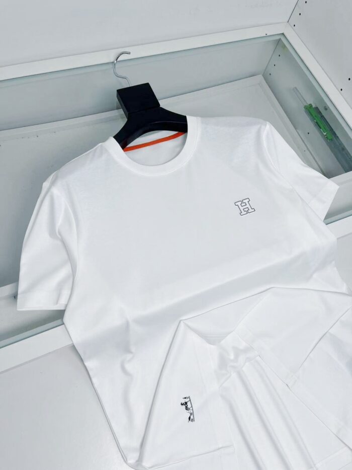 Maglietta bianca minimalista con logo sottile, semplice e elegante, su sfondo chiaro e moderno.