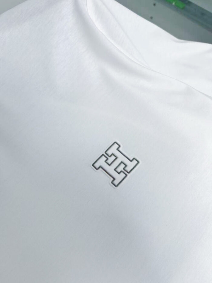 Maglietta bianca con logo minimalista nero, stile Casual e di alta qualità.