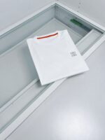 Maglietta bianca minimalista con logo discreto e dettaglio rosso sul colletto, stile moderno e versatile.