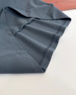 Maglietta sportiva in tessuto blu grigio, minimalista e comoda, ideale per attività e casual wear.
