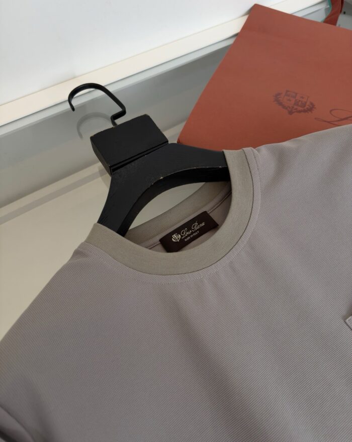 Camicia moderna con dettagli contrasto, in tessuto morbido, abbinata a accessorio elegante in pelle.