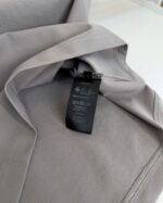 Vestito grigio elegante con etichetta minimalista, stile raffinato e design moderno.
