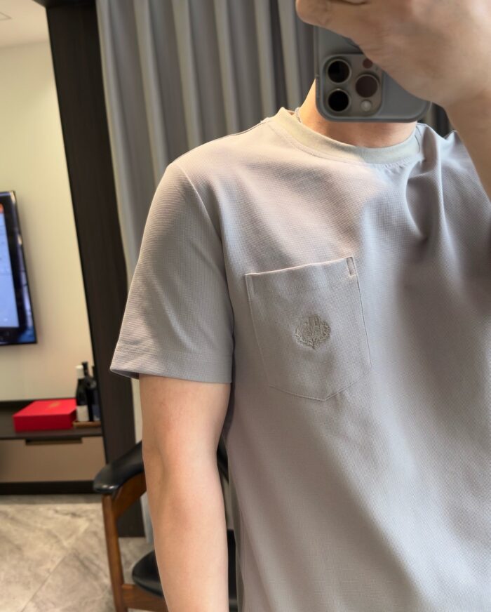 Abito casual con camicia grigia in stile moderno, ambientazione domestica minimalista e raffinata.