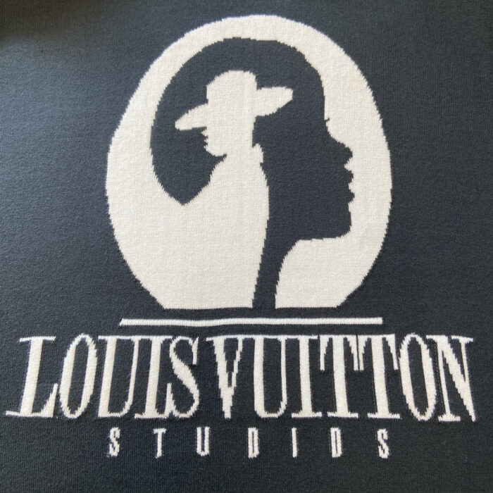 Logo Louis Vuitton elegante con silhouette raffinata e testo STUDIOS su sfondo nero.