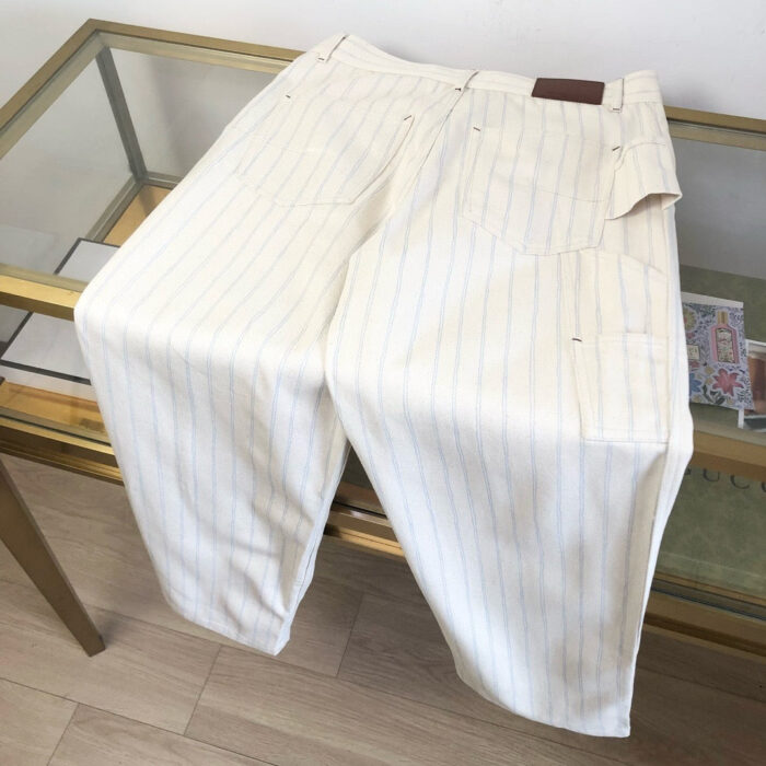 Pantaloni bianchi eleganti a righe blu, bordo classico, perfetti per outfit estivi e casual chic.