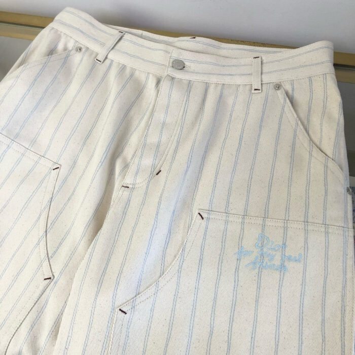 Pantaloni a righe pastel moderni e casual, con tasche e dettagli ricamati, ideali per ogni occasione.