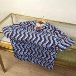 Camicia estiva con motivo a onde blu e rosso, stile casual e design vivace.