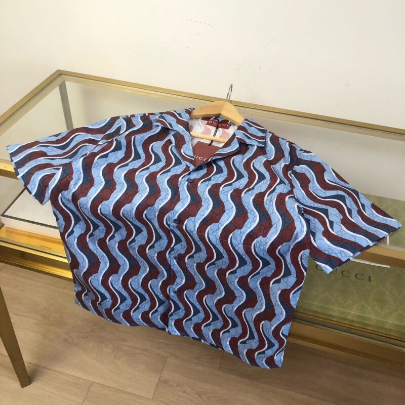 Camicia estiva con motivo a onde blu e rosso, stile casual e design vivace.