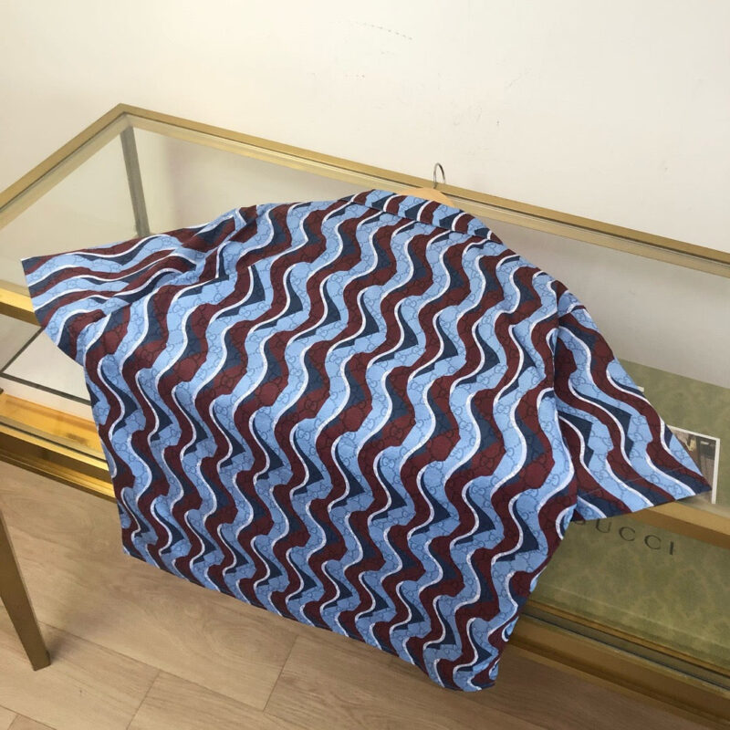 Tessuto a onde blu e rosso su tavolo di vetro con cornice dorata, stile elegante e moderno.