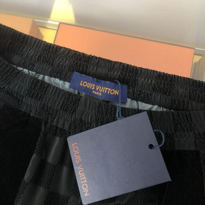 Pantaloni Louis Vuitton in tessuto check luxury con logo dorato e cintura elasticizzata elegante.