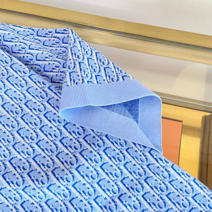 Tessuto blu con motivi intricati e bordo a contrasto, perfetto per abbigliamento elegante.