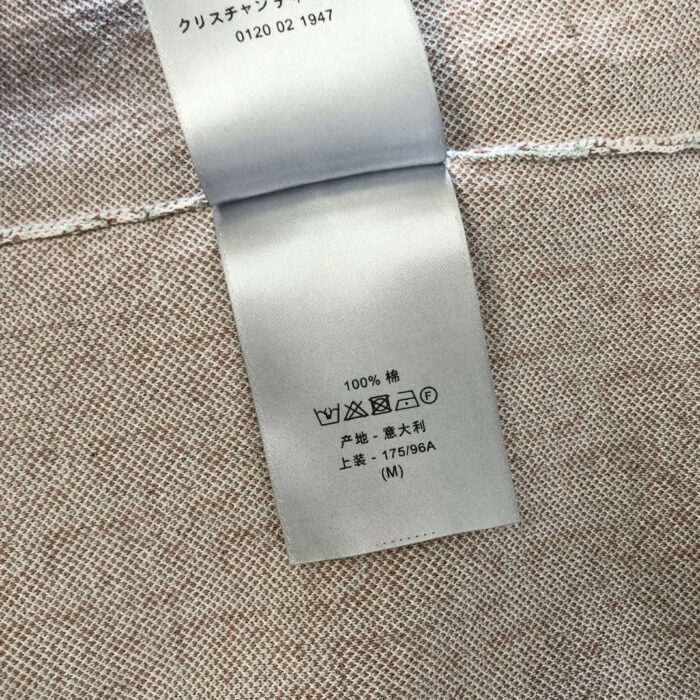 Etichetta di abbigliamento in cotone, tag size M, logo e dettagli del prodotto.