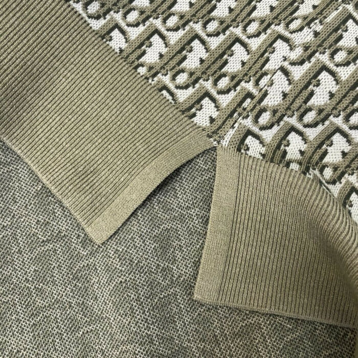 Tessuto a maglia verde e beige con motivo geometrico e dettaglio a costina.