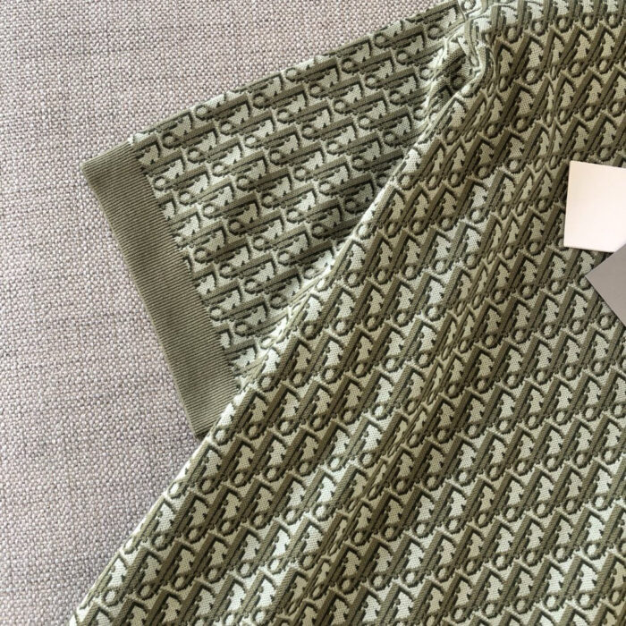 T-shirt verde oliva con dettagli eleganti, pattern raffinato e polsini a costine di stile moderno.