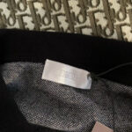 Etichetta Dior su maglione nero di lusso, dettagli eleganti e tessuto a maglia raffinato.