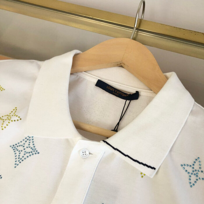 Maglietta polo bianca con motivi colorati, dettagli eleganti e stile casual chic.