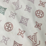 Tessuto di lusso con loghi colorati e rhinestones scintillanti, perfetto per moda elegante e glamour.