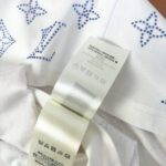T-shirt bianco con strass blu e dettagli a stella, care label visibile.