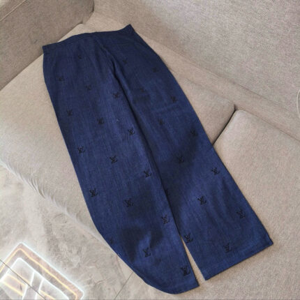 Pantaloni navy con ricami eleganti su divano beige, stile casual e sofisticato.