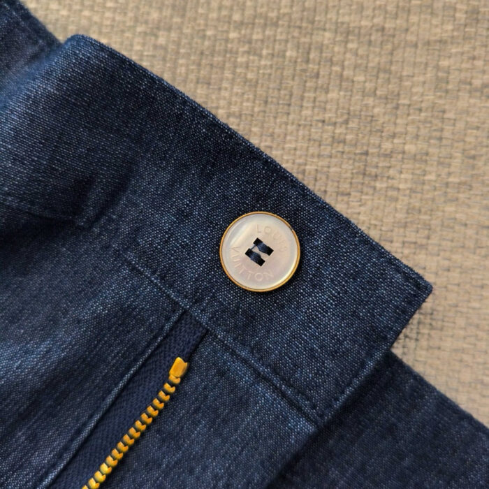 Jeans blu con bottone, cerniera dorata e dettagli di alta qualità.