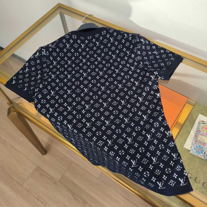 Polo di lusso con logo bianco e motivi geometrici su tessuto navy elegante.