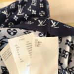 Tessuto di lusso con pattern logo, etichette internazionali, stile elegante e versatile.
