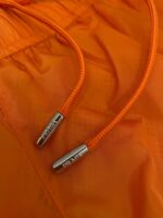 Cordini arancioni con aglet in metallo su giacca sportiva colorata